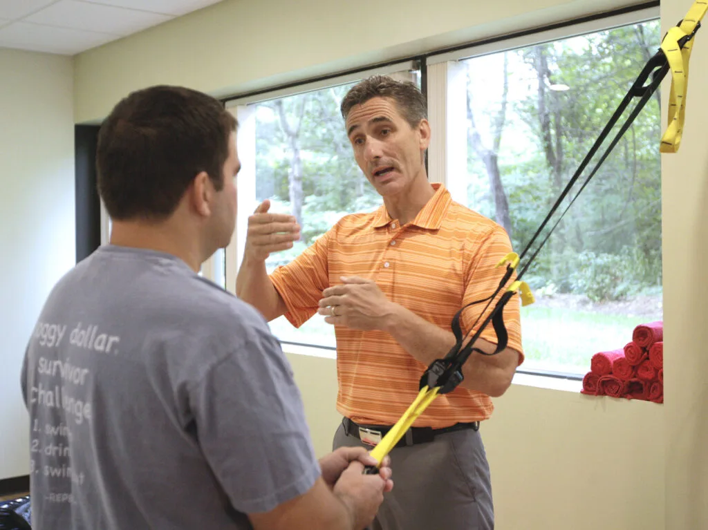 Dr. Chapman coaching a patient through a suspension-strap exercise